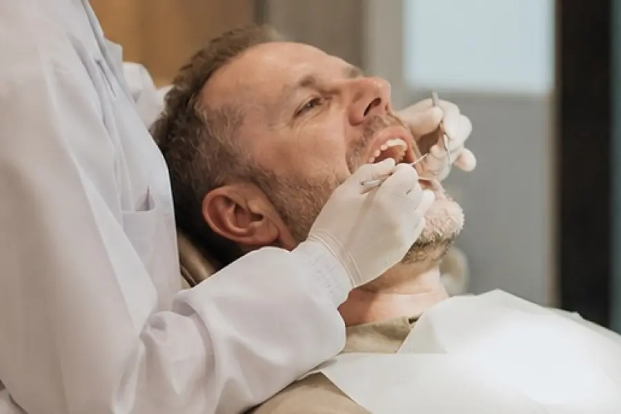 Thai dentist providing dental treatment to an international patient in a modern clinic in Thailand.